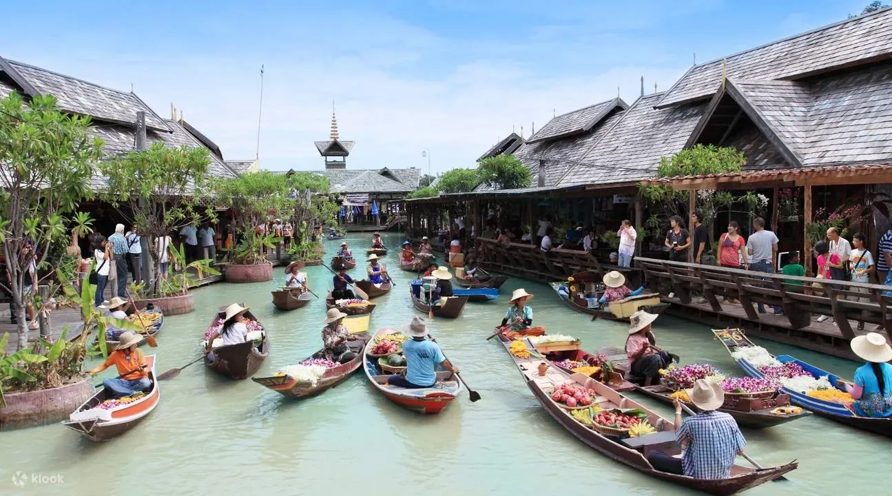 This market has colorful boats, wooden walkways, food stalls, and Thai-style buildings.